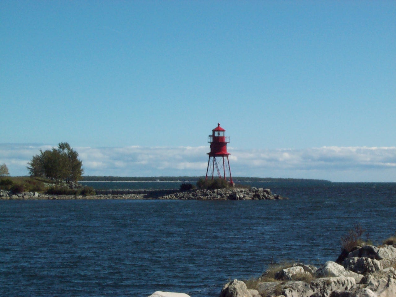 The bright red Alpena Pier Light marking the Thunder Bay River entrance. Alpena, Michigan.