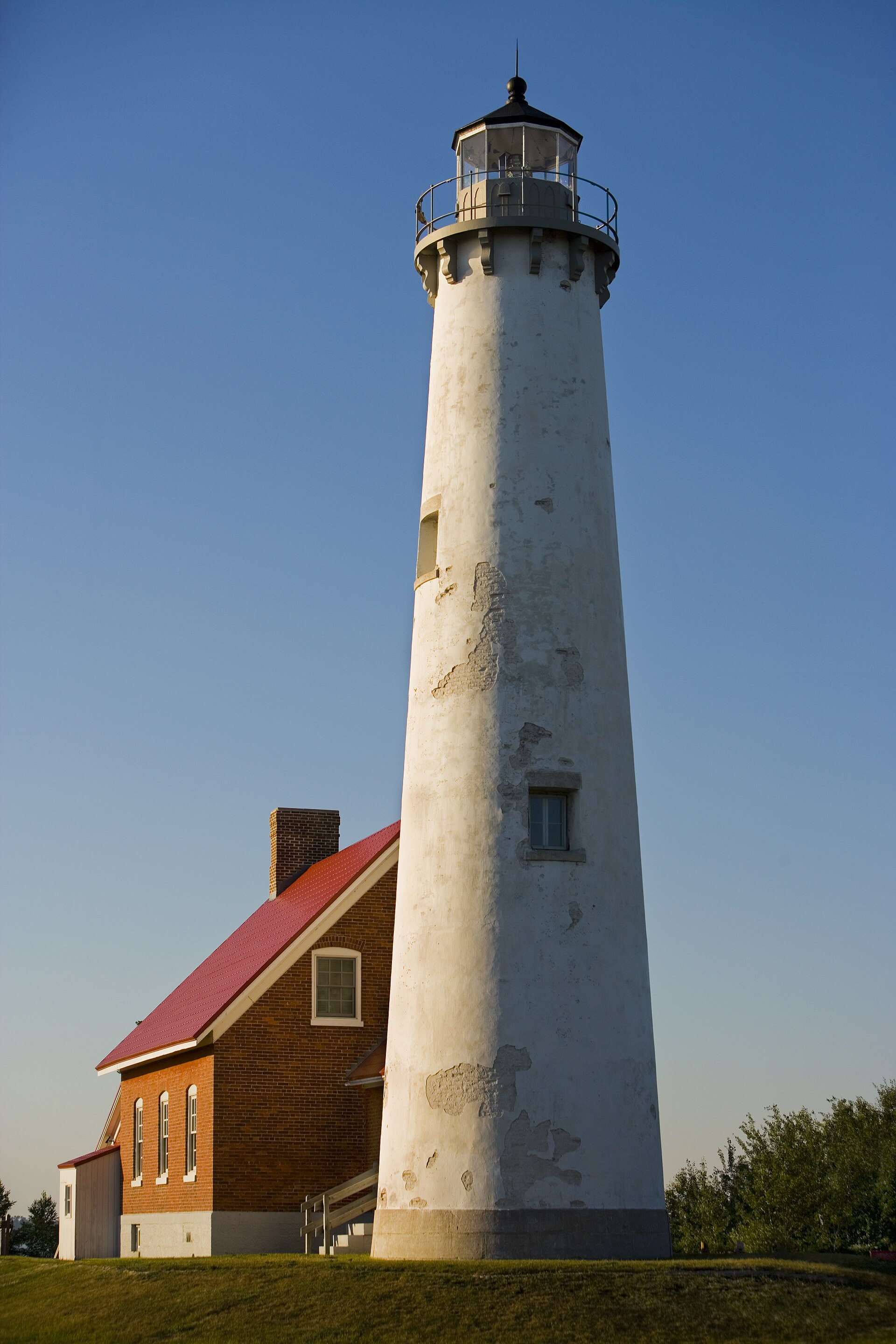 Tawas Point Lighthouse, a barber-pole brick tower on a sand spit. Tawas City, Michigan.